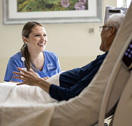 Doctor talks with patient at her bedside