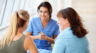 Three women talking at a hospital