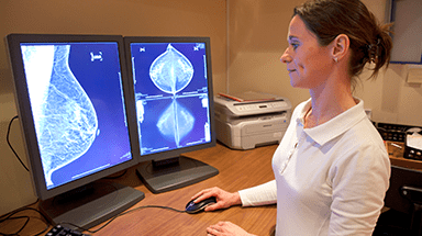 Health care provider viewing mammogram on computer screen