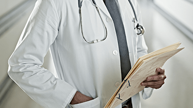 Doctor in white lab coat, holding patient chart