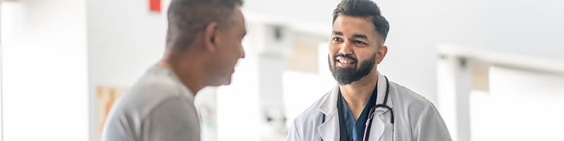 Male doctor conversing with his male patient.