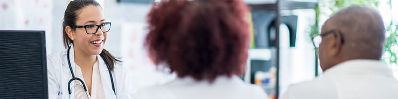 Female doctor speaking with a couple.
