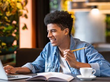 College-aged boy working on a laptop