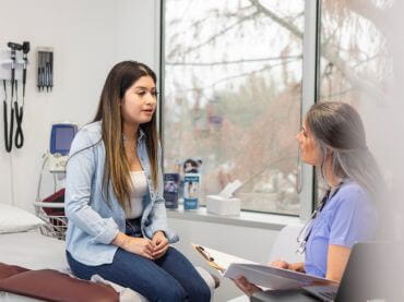 Healthcare provider talking to an older teen girl