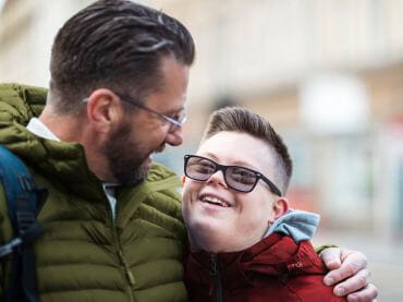 Father and son looking at each other and smiling.