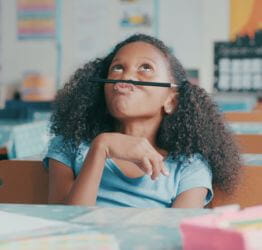 Girl balancing a pencil on her nose