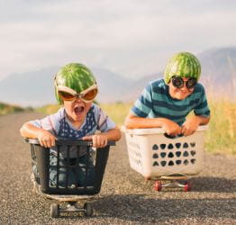Kids riding skateboards in clothes baskets