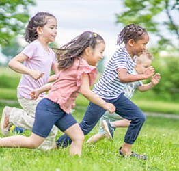 Kids running together outside in the grass