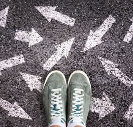 Person standing on arrow chalk drawings 