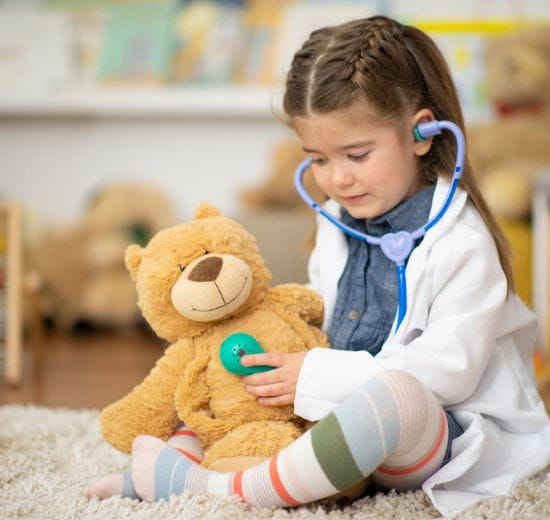 Child listening to heartbeat of teddy bear