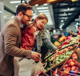 Dad and child picking out apples in the store