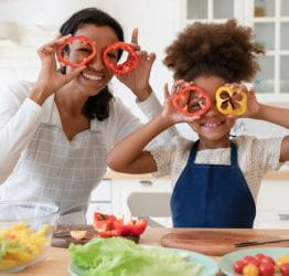 Mom and child holding pepper rings up to their eyes like glasses