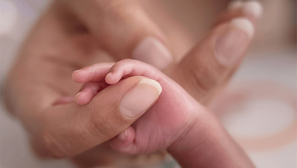 Woman holding a babies hand