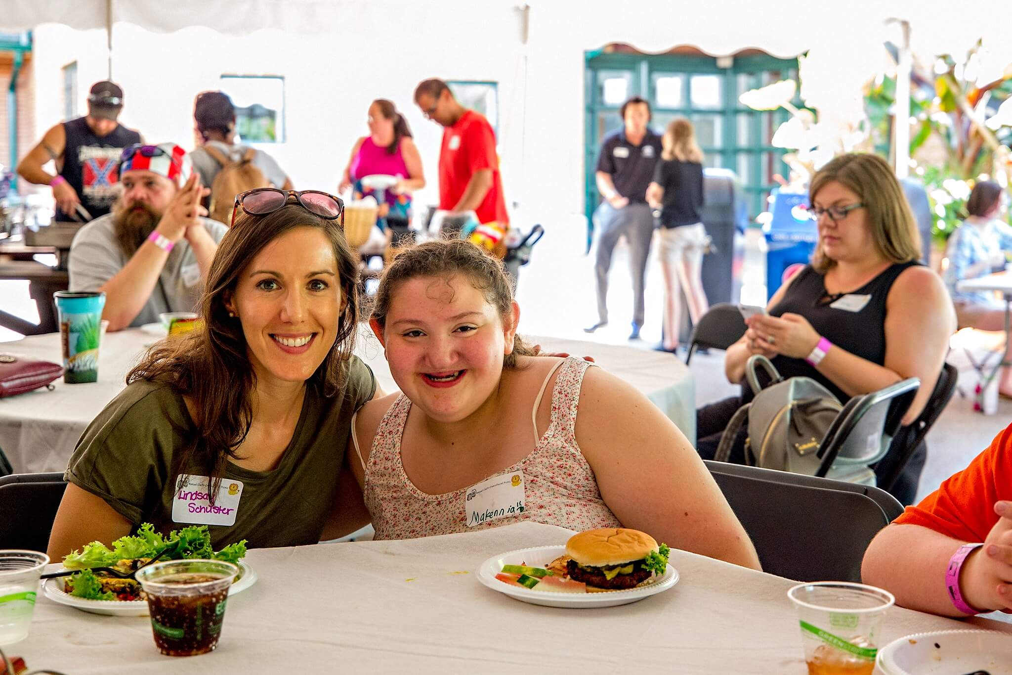 Two people smiling and having fun at the Annual Cleft-Craniofacial Center Picnic.