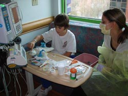 Beth Moneck, MS, CCLS, CIMI sits with heart patient Aaron Amon.