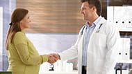Pregnant woman meeting a doctor and shaking his hand