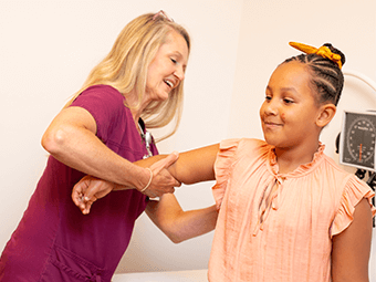 Young girl getting her arm checked out by her doctor
