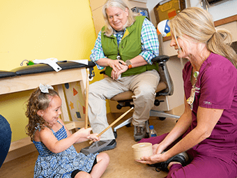 Toddler sitting on the floor with her doctor