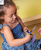 Toddler using scissors with her doctor