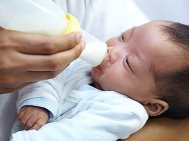 Infant drinking milk out of a bottle