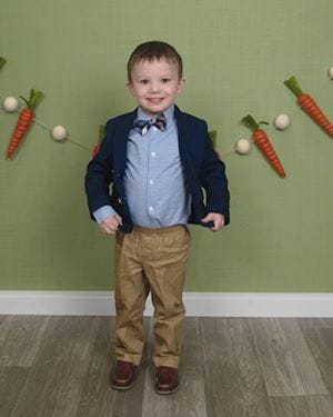 hayden in a suit in front of a carrot garland