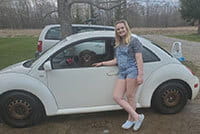 Katelyn Dougherty standing in front of her car with her dog