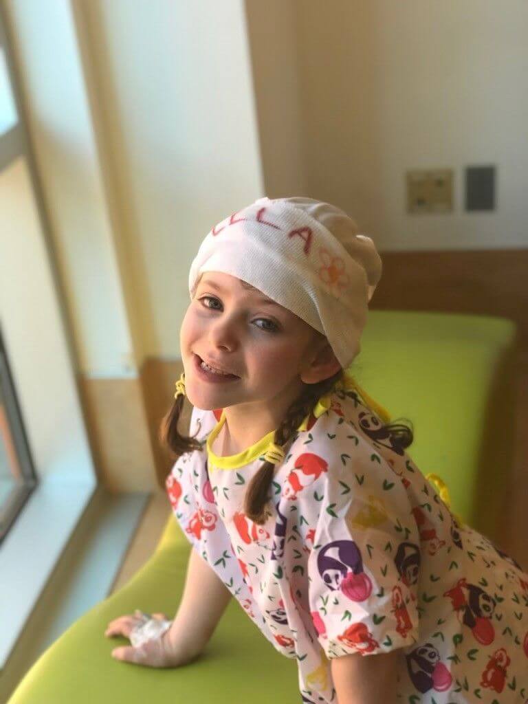 Ella Weisbord standing by a window and smiling at the camera