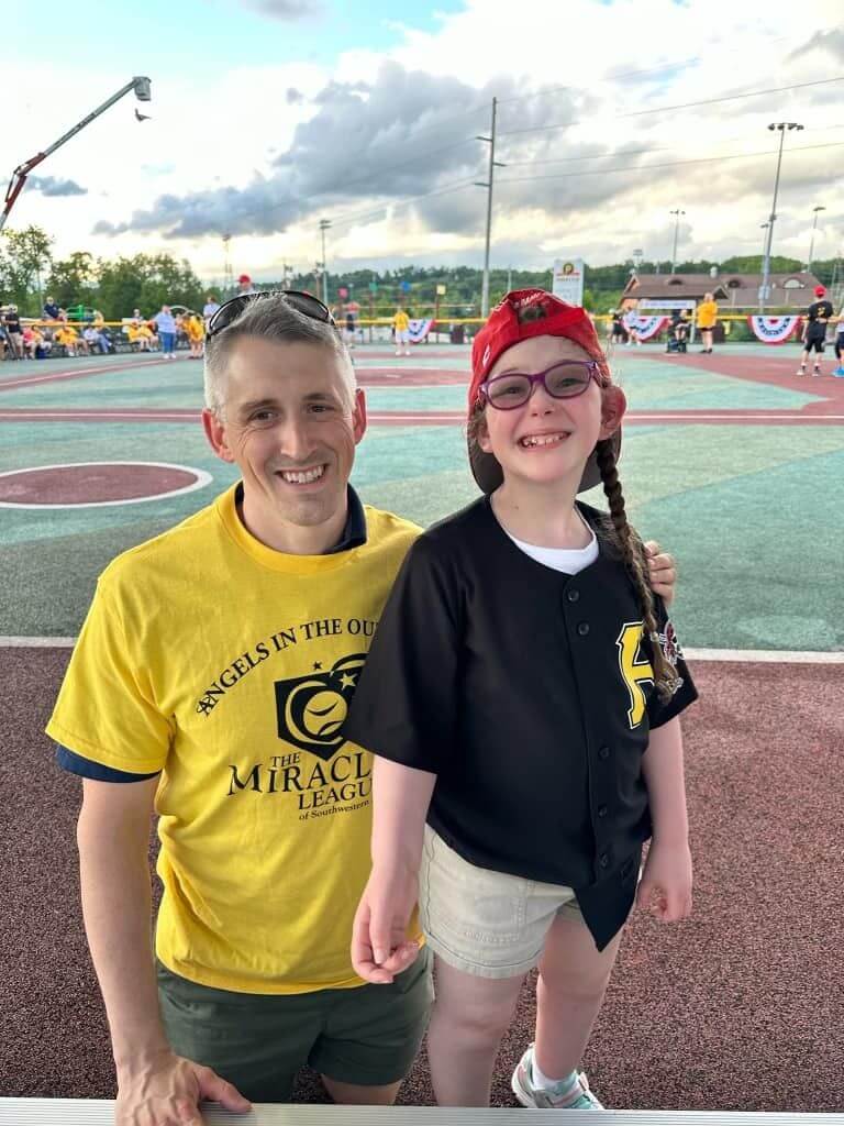 Ella Weisbord wearing a pirates shirt and smiling at the baseball field