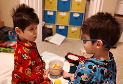Jayden and Josiah looking at each other in a playroom