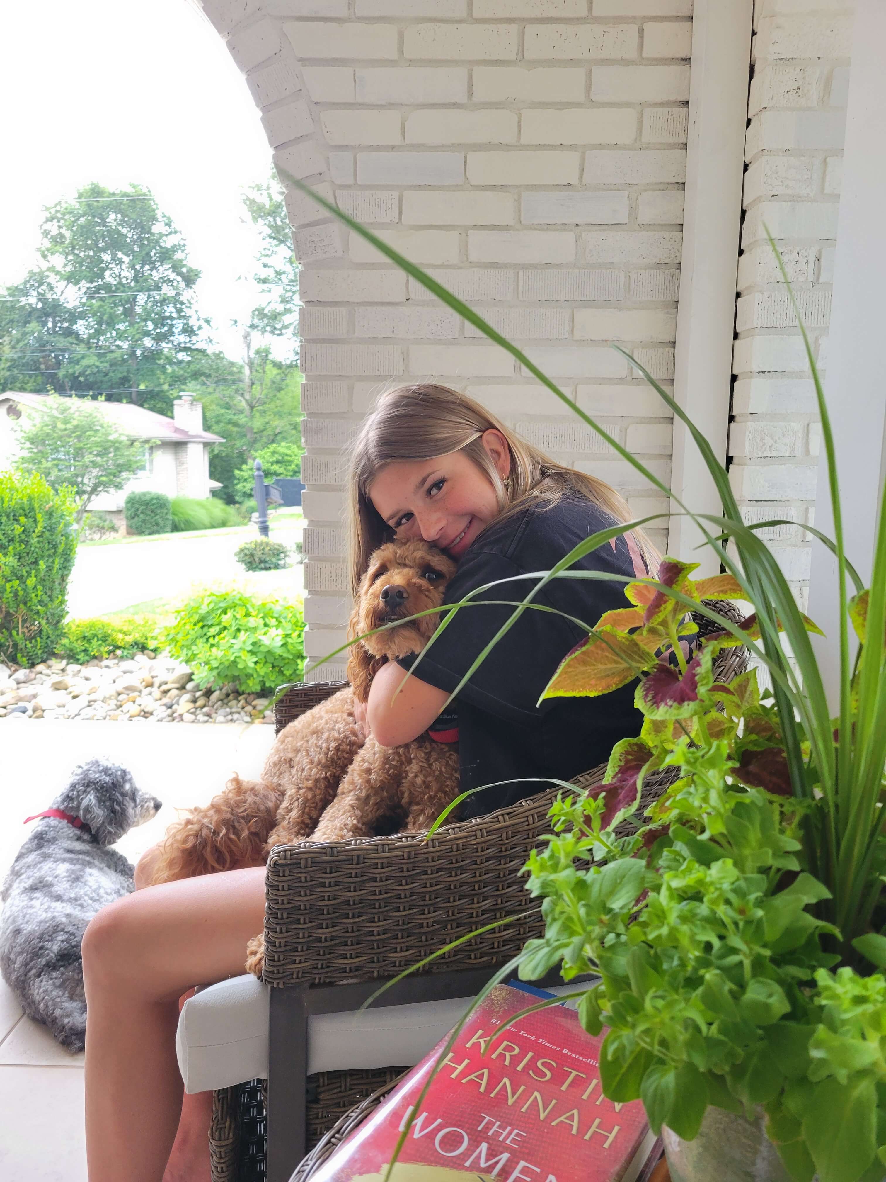 Alaina sitting on a chair with a dog in her lap