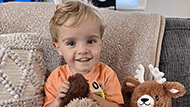 A young boy named Asher holding a stuffed animal