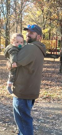 Baby Matthias being carried on a path in the woods.
