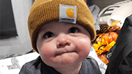 Matthias as a baby wearing a mustard color beanie