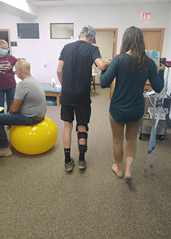 Logan walking with a woman helping him