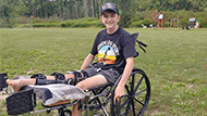 Logan in a wheelchair with his leg elevated
