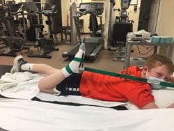 Zach in physical therapy stretching his leg