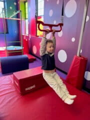 Hayden hanging by his arms on a toy