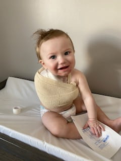 Hayden smiling in a sling