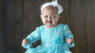 Madelynn Reddinger as a baby in a blue dress