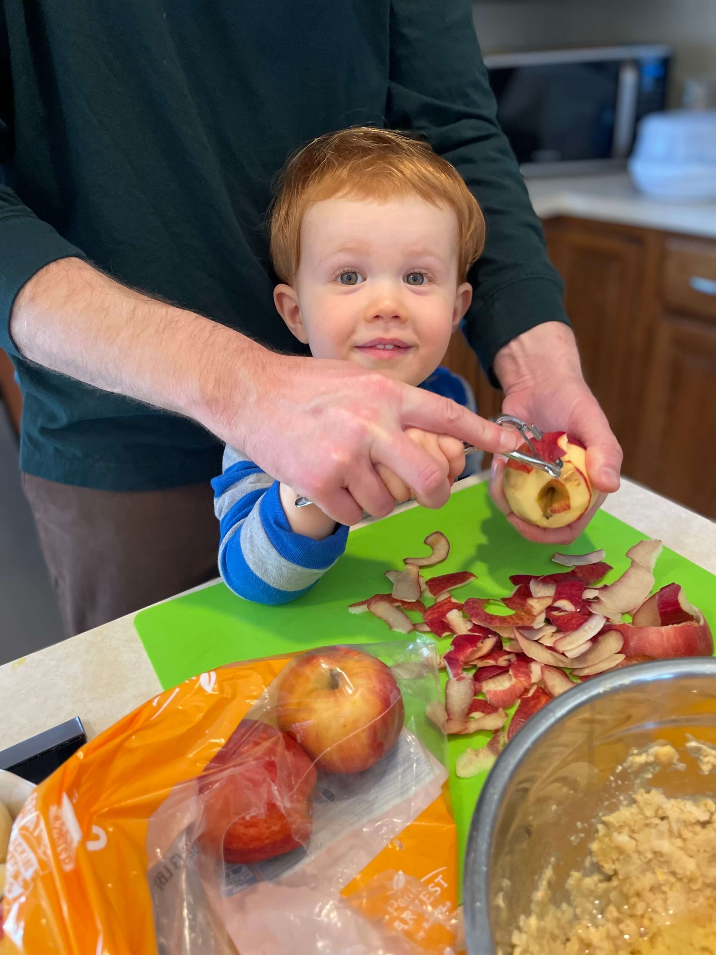 Andrew Cranshaw peeling apples with the help of a parent