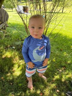 Jaxson Harris in a blue swim shirt and bathing suit