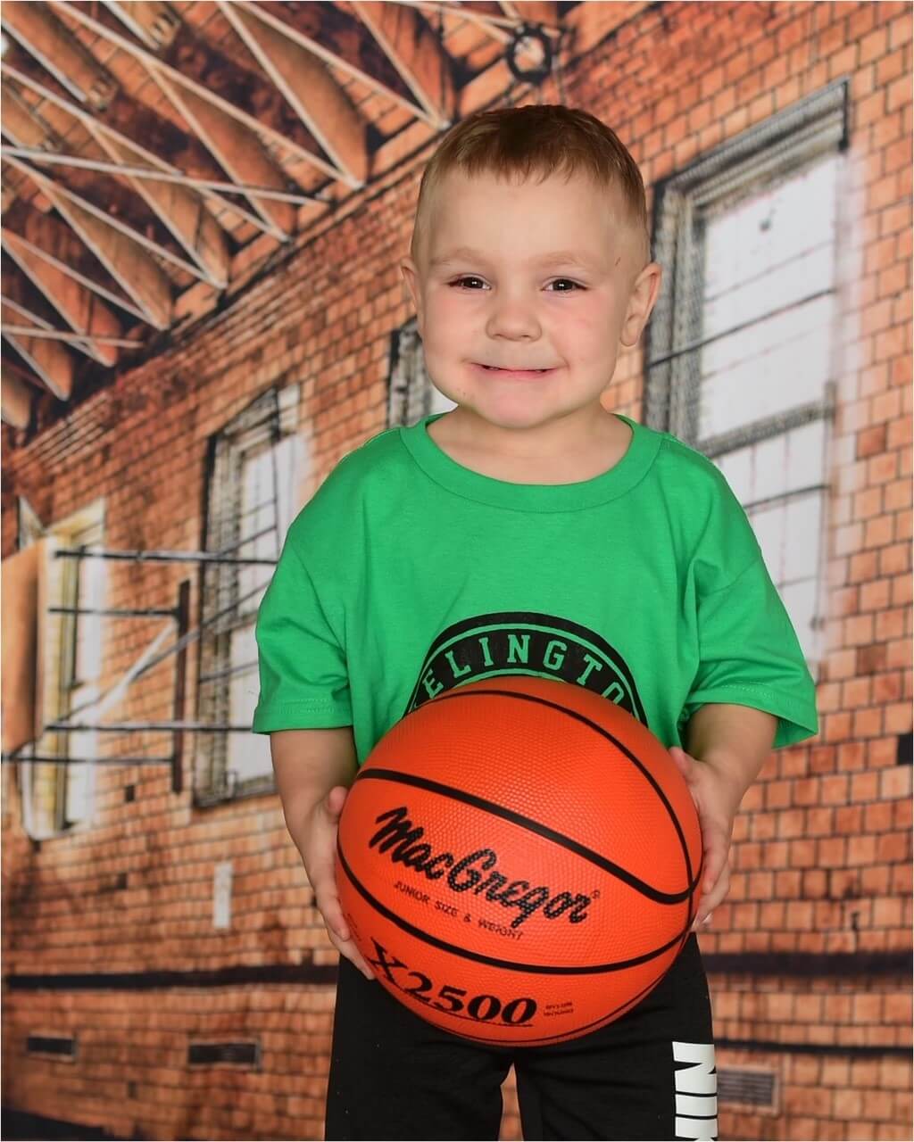 Jaxson Harris in a green uniform holding a basketball