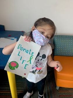 Liliana holding a sign that says 'Donate Life'