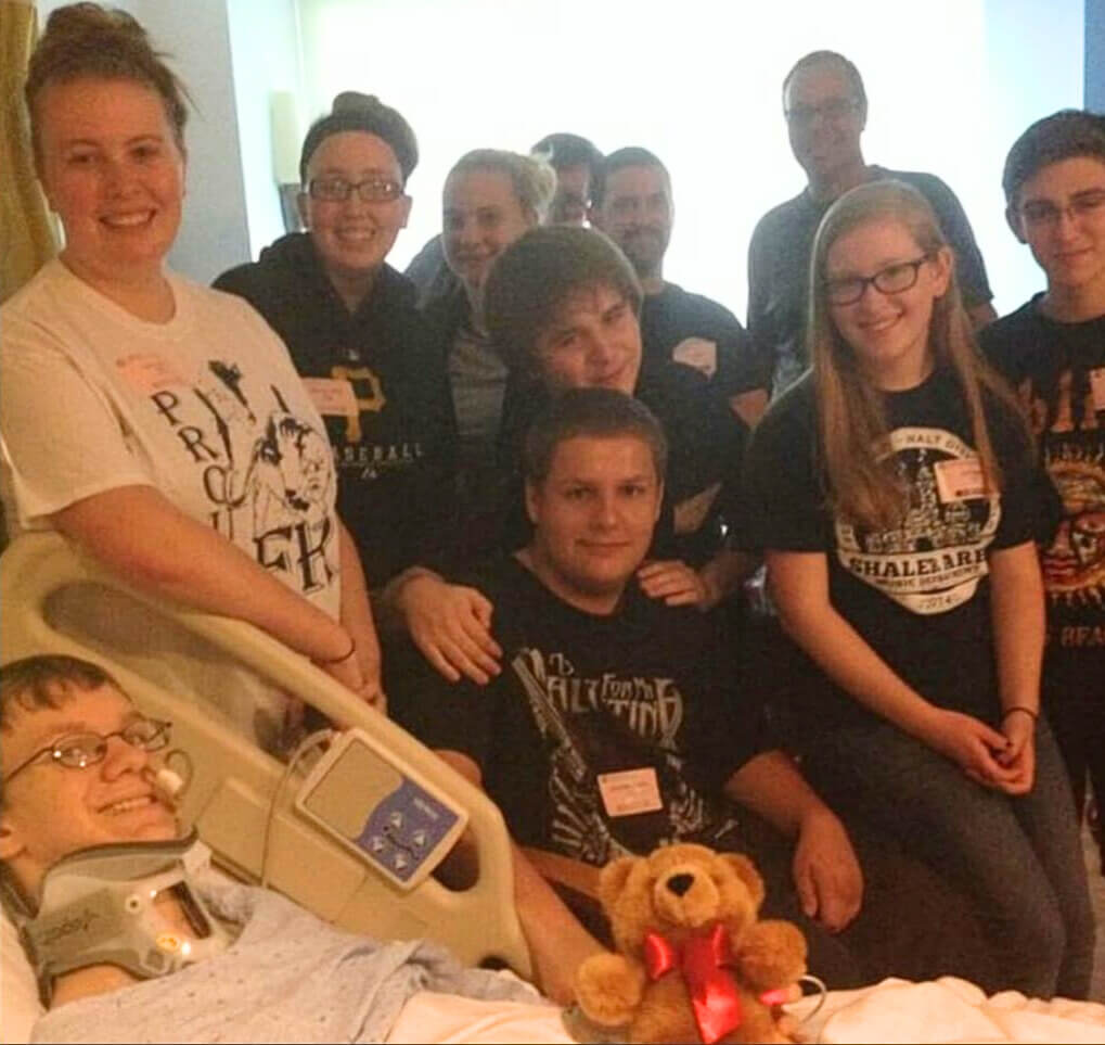 John Richardson in the hospital surrounded by friends and family