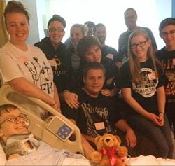 John Richardson in the hospital surrounded by friends and family