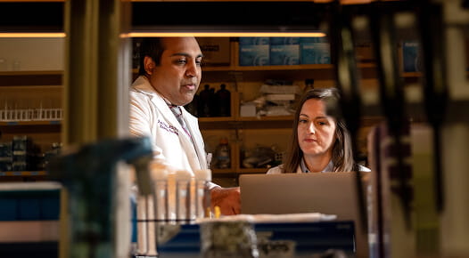 Image of providers talking and looking at computer screen.