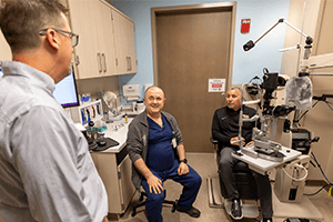 (From left) Drs. Conner and Boris Rosin discuss with Evan Facher his vision-test results—20/25 with his glasses—nearly two years after a sports accident that seriously injured his left eye.