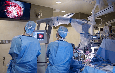 Image of surgeons looking at screen during a procedure.