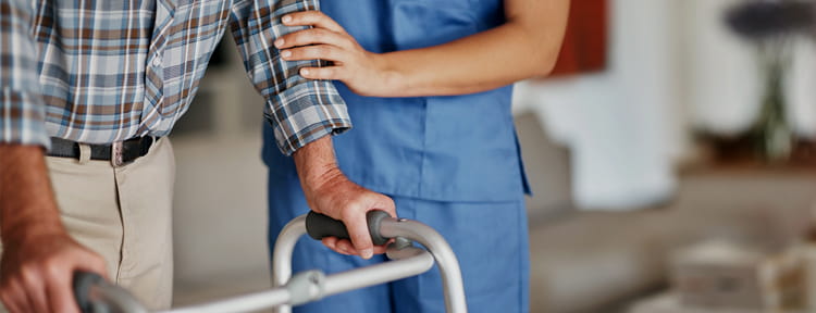 UPMC Physician Resources Geriatrics Photo of Nurse Helping Patient with Walker