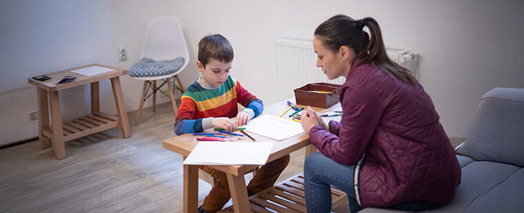 Child and adult sitting at a table
